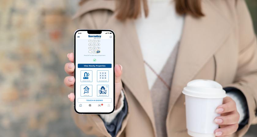 Woman holding phone showing SentriKey mobile app