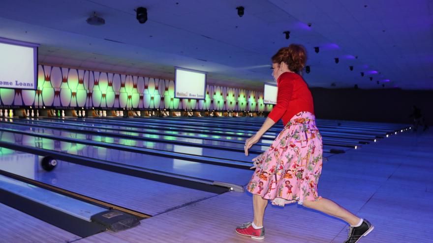 Bowler in costume mid-swing bowling