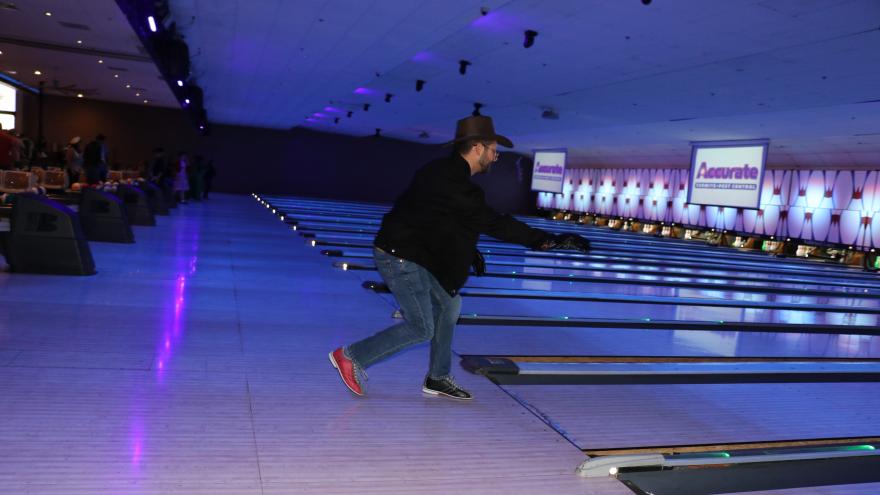 Bowler in costume mid-swing bowling