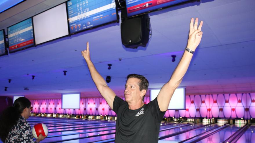 Bowler holding hands up in front of lanes