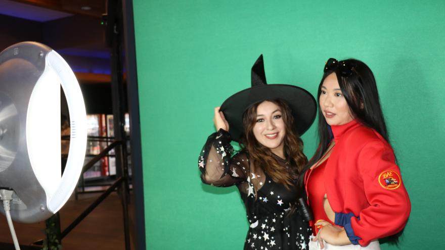 People in costume taking a picture at the selfie station in front of a green screen