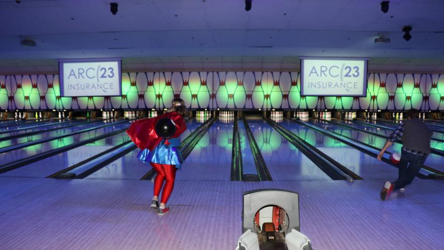 Guests throwing bowling balls down the lanes