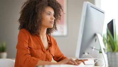 Cheerful businesswoman working on desktop computer